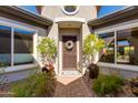 Charming home's entry featuring a decorative door, potted plants, and a welcoming doormat at 5414 E Palo Brea Ln, Cave Creek, AZ 85331