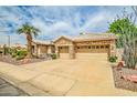 Beautiful home featuring a three-car garage, stone accents, tile roof, and mature landscaping at 6158 W Donald Dr, Glendale, AZ 85310