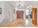 Inviting foyer featuring decorative tile flooring, high ceilings, and a grand wooden entrance door at 6158 W Donald Dr, Glendale, AZ 85310