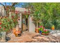 Inviting courtyard entrance with vibrant red flowers, terracotta pots, and a rustic wooden gate at 6301 N Camelback Manor Dr, Paradise Valley, AZ 85253