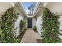 Inviting entryway with green foliage and a brick walkway leading to a classic black door at 6340 E Mitchell Dr, Scottsdale, AZ 85251