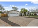 This inviting single-story home features a charming white exterior and a spacious brick driveway at 6340 E Mitchell Dr, Scottsdale, AZ 85251