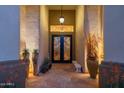 Inviting entryway featuring a wrought-iron door, flagstone flooring, and decorative potted plants for an elegant welcome at 8427 E Preserve Way, Scottsdale, AZ 85266