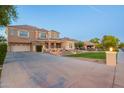 Expansive driveway leads to a charming two-story home with lush green lawn and mature landscaping at 950 E Desert Inn Dr, Chandler, AZ 85249
