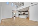 Bright living room with soaring ceilings and a modern kitchen featuring white cabinets at 100 W Northern Ave # 4, Phoenix, AZ 85021