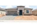 Charming single-story home with a gray tile roof, a two-car garage, and a covered entryway at 26949 W Lone Cactus Dr, Buckeye, AZ 85396