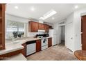 Bright kitchen with a skylight, white appliances, and tiled flooring at 2929 E Sequoia Dr, Phoenix, AZ 85050