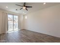 Bright bedroom featuring a ceiling fan, wood-look flooring, and a glass sliding door at 300 N Gila Springs Blvd # 144, Chandler, AZ 85226