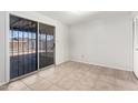 Bright living room featuring tile flooring, neutral walls and sliding glass doors at 5948 W Holly St, Phoenix, AZ 85035