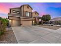 Inviting two-story home with a three car garage and desert landscaping at 6971 W El Cortez Pl, Peoria, AZ 85383