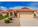 Charming front exterior features a well-manicured lawn, desert landscaping, and a tile roof at 7626 W Mcrae Way, Glendale, AZ 85308