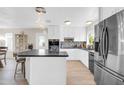 Bright kitchen with white cabinetry, stainless steel appliances, and center island with seating at 10543 E Sahuaro Dr, Scottsdale, AZ 85259