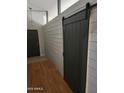 Welcoming entryway with wood-look floors and gray sliding barn door at 11590 W Cocopah St, Avondale, AZ 85323
