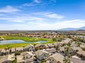 Beautiful aerial view of the community featuring lush green fairways, a scenic lake, and mountain views at 1248 E Briarwood Ter, Phoenix, AZ 85048