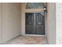 Close-up of the front door featuring a secure iron gate and tile flooring at 14841 N 62Nd Way, Scottsdale, AZ 85254