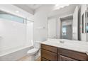 Well-lit bathroom featuring a tub, shower, vanity and toilet, offering a clean and functional design at 21296 N 270Th Ln, Buckeye, AZ 85396