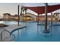 Community pool with shade canopies, lounge seating, and accessible entry points at 21316 N 271St Dr, Buckeye, AZ 85396