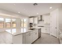 Bright, all-white kitchen featuring an island, stainless steel appliances, and tile flooring at 21830 E Bonanza E Ct, Queen Creek, AZ 85142