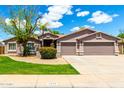 Attractive single-story home with a lush front lawn and a three-car garage on a sunny day at 2698 E Carla Vista Dr, Gilbert, AZ 85295