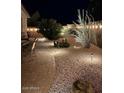 Backyard featuring desert landscaping, accent lighting, and a cozy patio area at 289 W Ironhorse Ln, San Tan Valley, AZ 85143