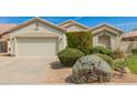 Charming single-story home with a two-car garage, desert landscaping, and a neutral color palette at 3871 S Marion Way, Chandler, AZ 85286