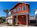 Charming two-story home features a red exterior with blue shutters and a well-manicured front yard at 399 N 157Th Ln, Goodyear, AZ 85338