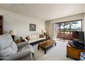 Bright living room with a sliding glass door to balcony, neutral carpet, and comfortable seating at 4303 E Cactus S Rd # 329, Phoenix, AZ 85032