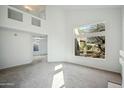 Open-concept living area with high ceilings, large windows offering natural light, and neutral carpeting at 4310 E Palo Brea Ln, Cave Creek, AZ 85331