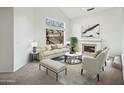 Bright living room featuring a fireplace, large window with backyard view, and neutral decor at 4310 E Palo Brea Ln, Cave Creek, AZ 85331