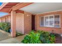 Inviting brick entryway with a security camera, manicured landscaping, and shuttered window at 5741 W Purdue Cir, Glendale, AZ 85302