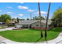 Beautiful single-story home with a green lawn, solar panels, and inviting front porch seating area at 601 E Winter Dr, Phoenix, AZ 85020