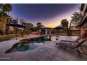 Stunning backyard oasis with a freeform pool, sun loungers, shaded cabana, and lush landscaping at 8755 E Gary Rd, Scottsdale, AZ 85260