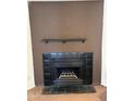 Classic black tiled fireplace with a dark mantel, set against a warm brown wall at 4820 N 89Th Ave # 45, Phoenix, AZ 85037