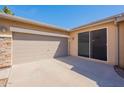 Attached two-car garage with neutral paint, an adjacent patio area, and partial stone exterior at 870 E Runaway Bay Pl, Chandler, AZ 85249