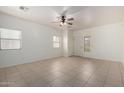 Bright living room with neutral tile flooring, ceiling fan and abundant natural light from large windows at 1384 E Press Rd, San Tan Valley, AZ 85140