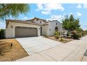 Single-Gathering home featuring stucco siding, a tile roof, landscaped front yard, and a two-car garage at 18001 W Cassia Way, Goodyear, AZ 85338