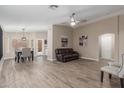Open-concept living room features stylish wood-look flooring, modern ceiling fan, and plenty of natural light at 3509 E Hazeltine Way, Chandler, AZ 85249