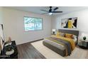 This primary bedroom features a ceiling fan, picture window and soothing decor at 5103 S Birch St, Tempe, AZ 85282