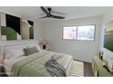 Bedroom with fan, picture window, and relaxing earth-tone colored decor at 5103 S Birch St, Tempe, AZ 85282