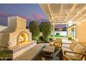 Backyard oasis featuring a beautiful stone fireplace and cozy seating area perfect for entertaining at 19162 E Mockingbird Dr, Queen Creek, AZ 85142