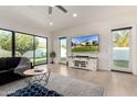 Inviting living room with a large TV, sliding glass doors to the backyard, and modern decor at 19162 E Mockingbird Dr, Queen Creek, AZ 85142