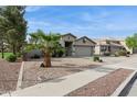 A well-maintained house with a two-car garage, desert landscaping, and a healthy palm tree in the front yard at 10605 W Windsor Ave, Avondale, AZ 85392