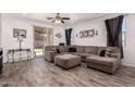 Spacious living room features stylish tile floors, a ceiling fan, and neutral tones at 12033 W Davis Ln, Avondale, AZ 85323