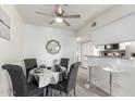 Cozy dining area with gray upholstered chairs, modern mirror, and a ceiling fan at 12123 W Bell Rd # 339, Surprise, AZ 85378