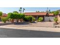 Charming single-story home with desert landscaping, mature trees and pavers leading to the front door at 1448 E Royal Palm Rd, Phoenix, AZ 85020