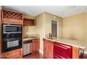 Compact kitchen featuring stainless steel appliances, wine rack and breakfast bar at 1448 E Royal Palm Rd, Phoenix, AZ 85020