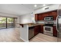 Bright kitchen with stainless appliances, granite countertops, wood cabinets, and an adjacent dining area at 20660 N 40Th St # 1112, Phoenix, AZ 85050