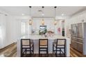 Well-appointed kitchen featuring a large island with bar seating, pendant lights, and stainless steel appliances at 22656 E Marsh Rd, Queen Creek, AZ 85142