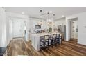 Modern kitchen boasts a spacious island with pendant lighting, white cabinets, and seating for a casual dining experience at 22656 E Marsh Rd, Queen Creek, AZ 85142