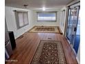 Open living room with wood floors, neutral walls, and large windows at 303 S Recker Rd # 74, Mesa, AZ 85206